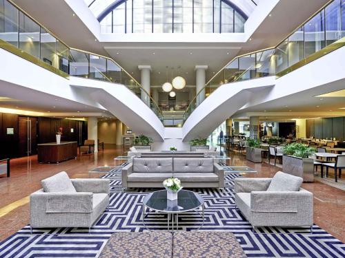 a lobby with couches and tables in a building at Novotel Sydney Parramatta in Sydney