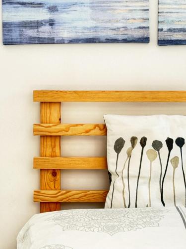 a bedroom with a bed with a wooden headboard at Nowy dom przy starym krześle - w Pelniku in Pelnik