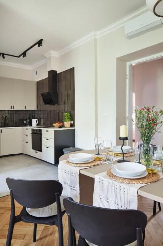 a kitchen and dining room with a table and chairs at PlayRoom Aparthotel in Krakow