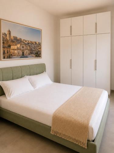 a bedroom with a large bed with white cabinets at Domus Palatium in Palazzolo Acreide
