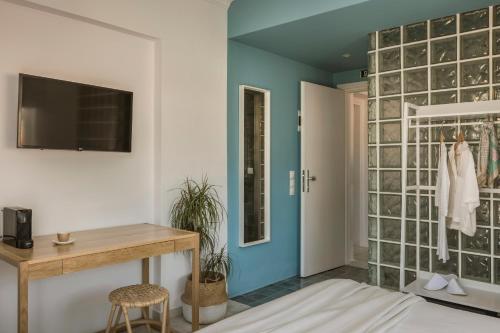 a room with a blue wall with a glass block wall at Aria Blue Suites in Skiathos