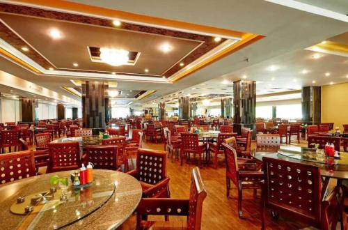 a restaurant with tables and chairs in a room at Ease Jomtien by Clubhouse in Jomtien Beach