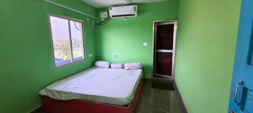 a small green room with a small bed in it at Om Siya Ram Resort in Rājgīr