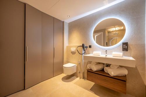 a bathroom with a sink and a mirror at Résidence San Petru - 4 étoiles in Porto-Vecchio