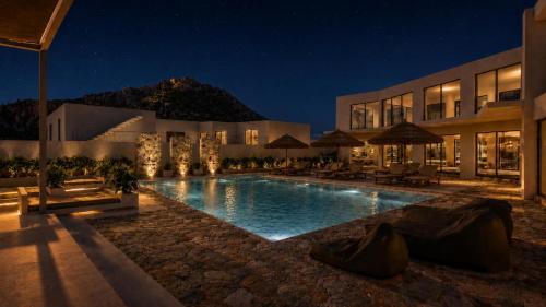 a hotel with a swimming pool at night at Grecale Filoxenia in Vrachonisída touArchangélou