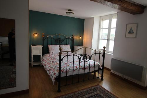 a bedroom with a bed and a green wall at La Chandeler in Juvigny-sous-Andaine