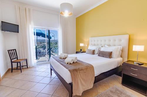 a bedroom with a large bed and a balcony at Villa Belchior by Algarve Holidays in Faro