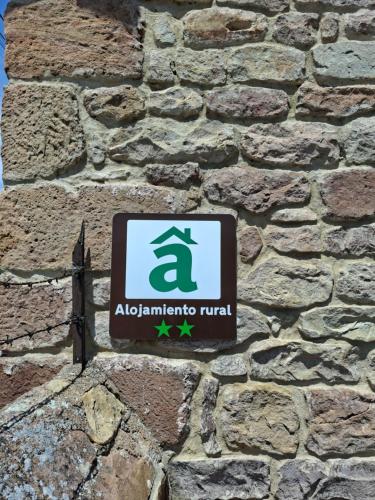 a sign on the side of a stone wall at La Posada De Faustina in Naveda