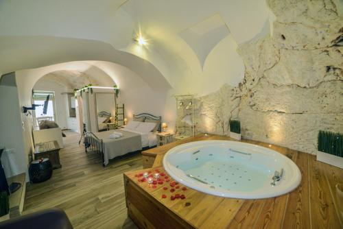 a large bath tub in a room with a bedroom at Suite Grotta della luna - Romantic Luxury Jacuzzi in Ostuni