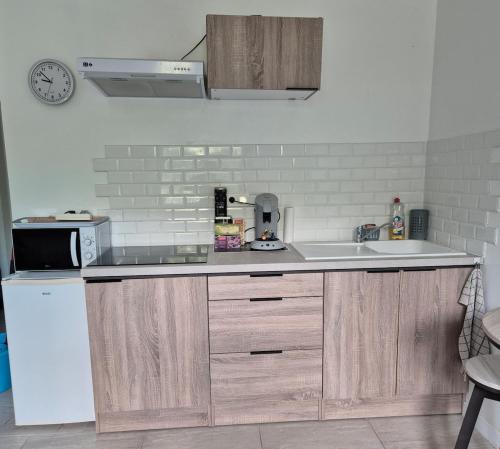 a kitchen with a white refrigerator and a sink at Studio centre-clim-parking privée-rdc in Saint-Gaudens