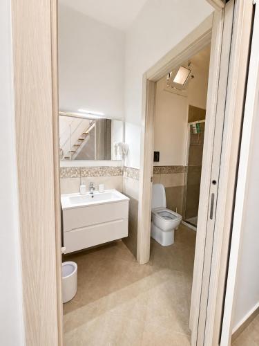 a bathroom with a sink and a toilet and a mirror at Bukowski Loft House in Porticello