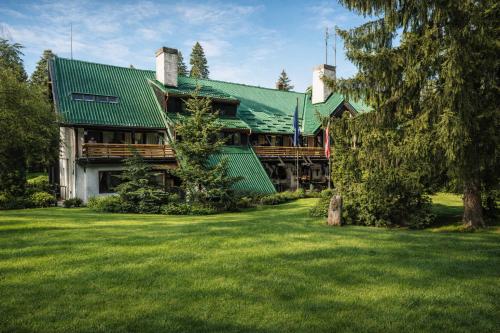 a large house with a green roof and a yard at Chalet Evergreen in Borovets