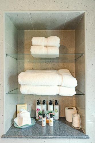 a shelf with towels and other products in a bathroom at Fischers Baslow Hall - Chatsworth in Baslow