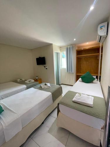 a hotel room with two beds and a television at Pousada Tropical Maragogi in Maragogi
