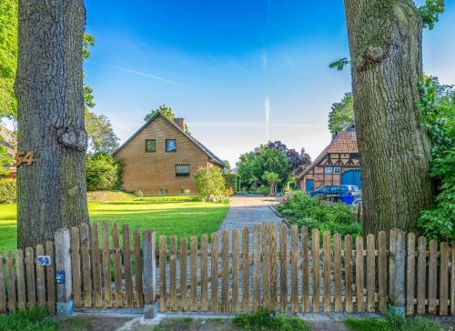 a wooden fence in front of a house with trees at Ferienwohnung KOTE in Dannenberg