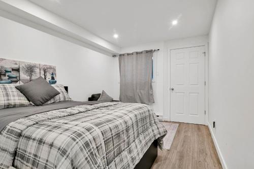 a white bedroom with a bed and a window at Elegance comfort à Montreal in Montreal