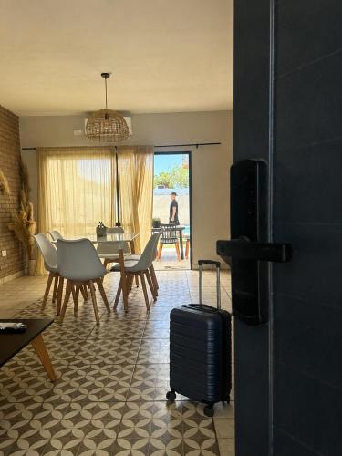 a living room with a table and chairs with a suitcase at Calma in Miramar