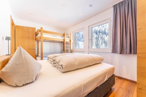 a bedroom with two bunk beds and two windows at Elisabeth Appartements in Damuls