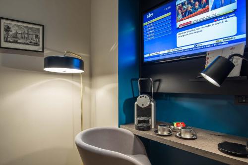 a room with a desk with a chair and a tv at Navona Street Hotel in Rome