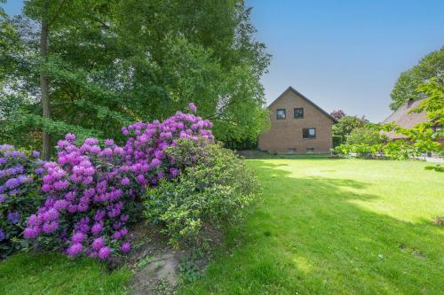 a bush of purple flowers in front of a house at Ferienwohnung KOTE in Dannenberg