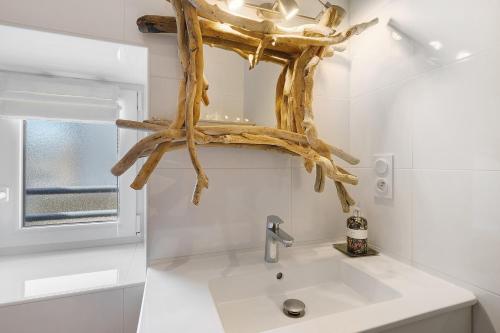 a bathroom with a sink with a branch above it at Ti Illiz in Le Conquet