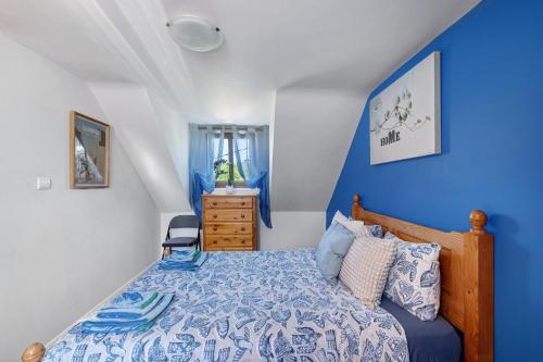 a bedroom with blue walls and a bed with a blue bedspread at La Poya in Plonévez-du-Faou