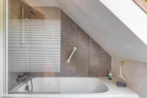 a white bath tub in a bathroom under a staircase at La Poya in Plonévez-du-Faou