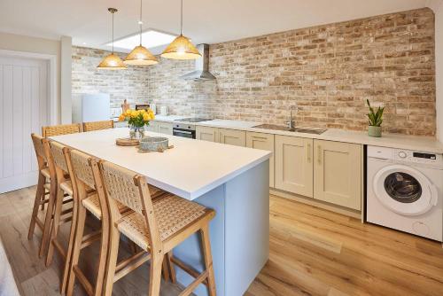 a kitchen with a table and chairs and a brick wall at Host & Stay - Puffin Cove in Seahouses