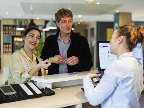 a group of people standing around a counter in a store at Aparthotel Adagio Access Le Havre Les Docks in Le Havre