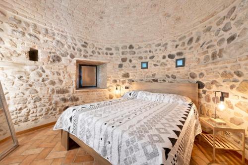a bedroom with a bed in a stone wall at Casa Dolca Casa La Torre in Pozzolengo