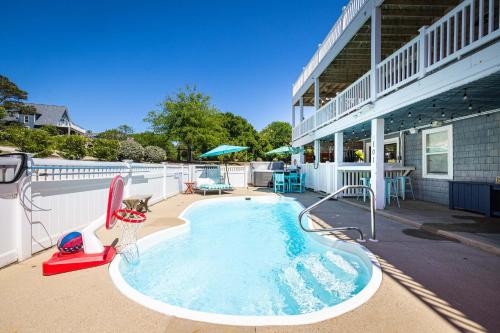 a swimming pool on the side of a house at Pool & Spa Game Rm Walking Distance to Beach & Shops in Duck