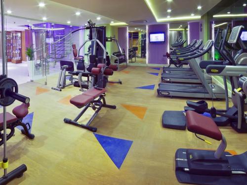 a gym with several treadmills and exercise bikes at Novotel Suites Riyadh Olaya in Riyadh