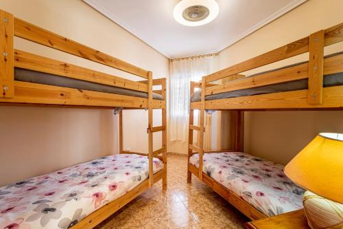 a bedroom with two bunk beds and a lamp at Lopimar Aurora in Canet de Berenguer