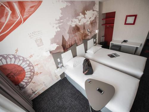 two beds in a hotel room with at ibis Styles Poitiers Centre in Poitiers