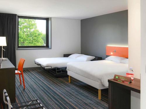 a hotel room with two beds and a window at ibis Styles Caen centre gare in Caen