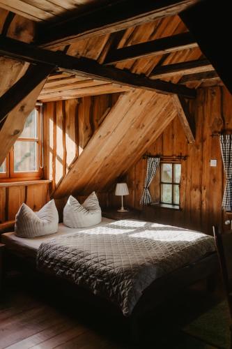 a bedroom with a large bed in a wooden building at Wysoka 5 in Szklarska Poręba