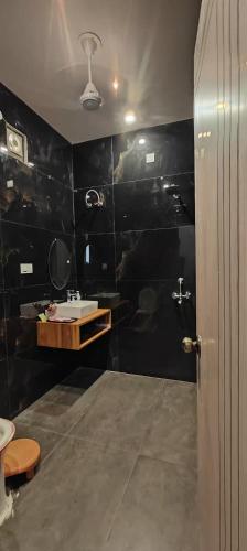 a bathroom with a sink and a black wall at Angad Farms in Kharar