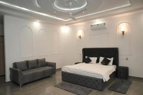 a bedroom with a bed and a couch in it at Angad Farms in Kharar