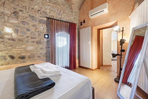 a bedroom with a bed and a stone wall at Casa Dolce Casa Al Castello in Pozzolengo
