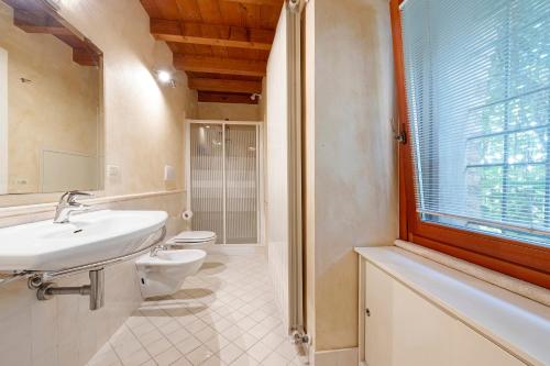 a bathroom with a sink and a toilet and a window at Casa Dolce Casa Al Castello in Pozzolengo
