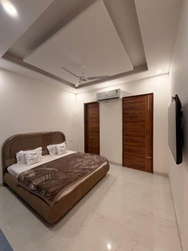 a bedroom with a large bed and a television at Urban Nest By Jassi in Kharar