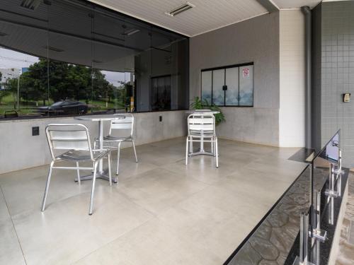 a patio with two chairs and a counter with a table at Hotel Boa Vista by Carlton in Americana