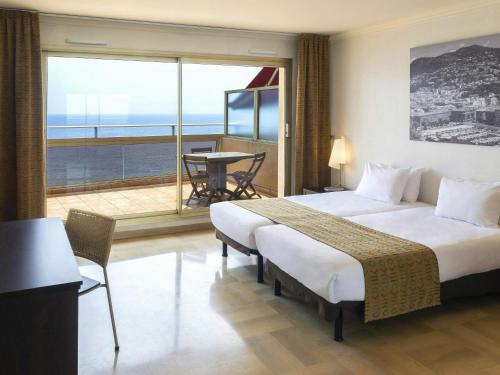 a hotel room with a large bed and a balcony at Aparthotel Adagio Nice Promenade des Anglais in Nice