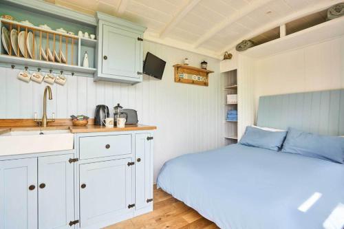 a bedroom with a bed and a kitchen with a sink at Host & Stay - Shepherds View in Alburgh
