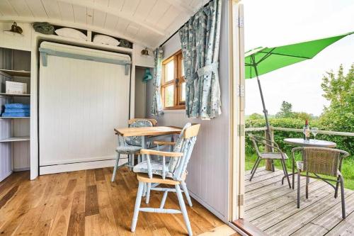 a porch with a table and chairs and an umbrella at Host & Stay - Shepherds View in Alburgh