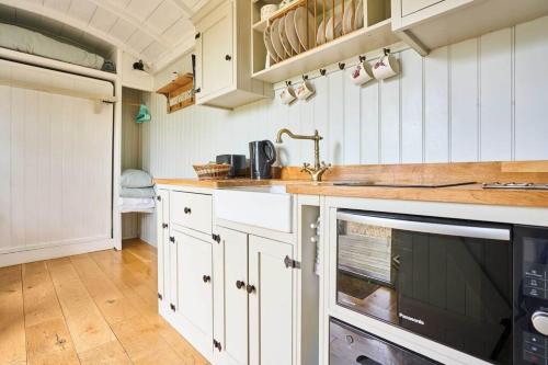 a kitchen with white cabinets and a sink at Host & Stay - Shepherds Delight in Alburgh