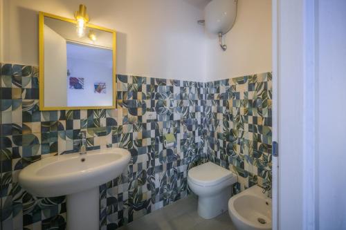 a bathroom with a sink and a toilet and a mirror at La Colombaia Bed and Rooms in Belvedere Marittimo