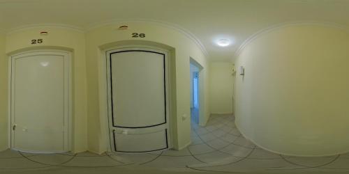 a hallway with two white doors and a mirror at Hospedaria do Almargem in Quarteira