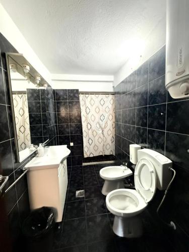 a bathroom with two toilets and a sink and a mirror at Majka Guest House in Kotor