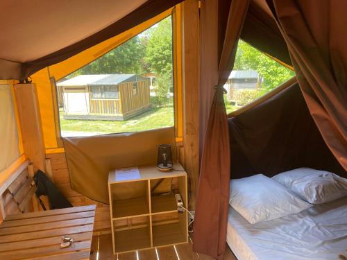 a small tent with a bed and a small table at Camping Onlycamp les Cochards in Seigy